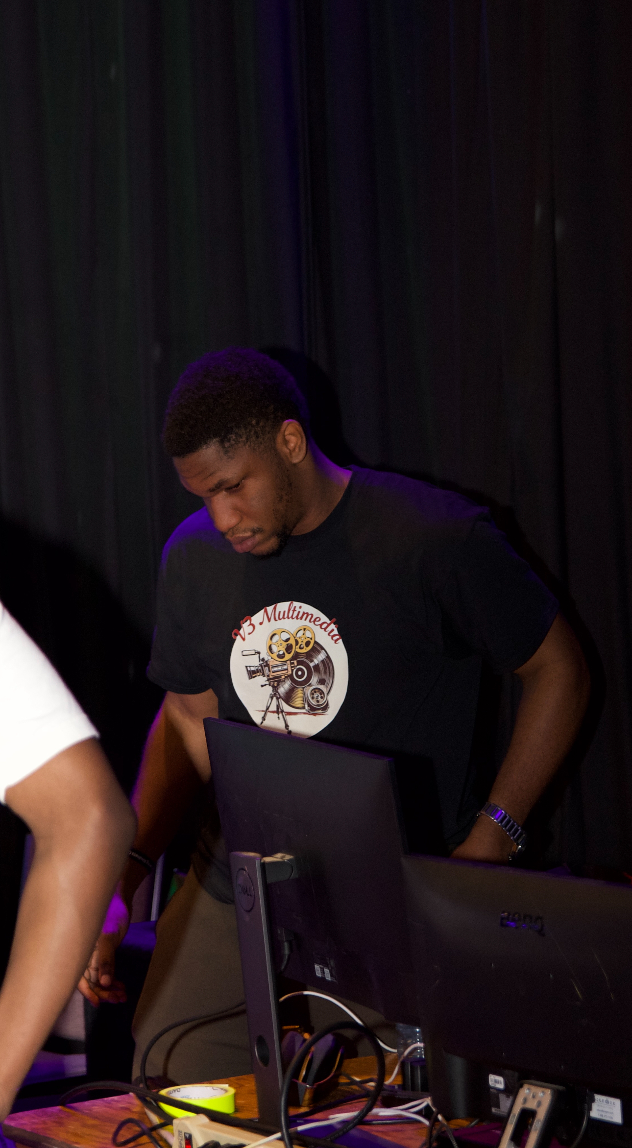 V3 Multimedia technician adjusting stage lighting equipment